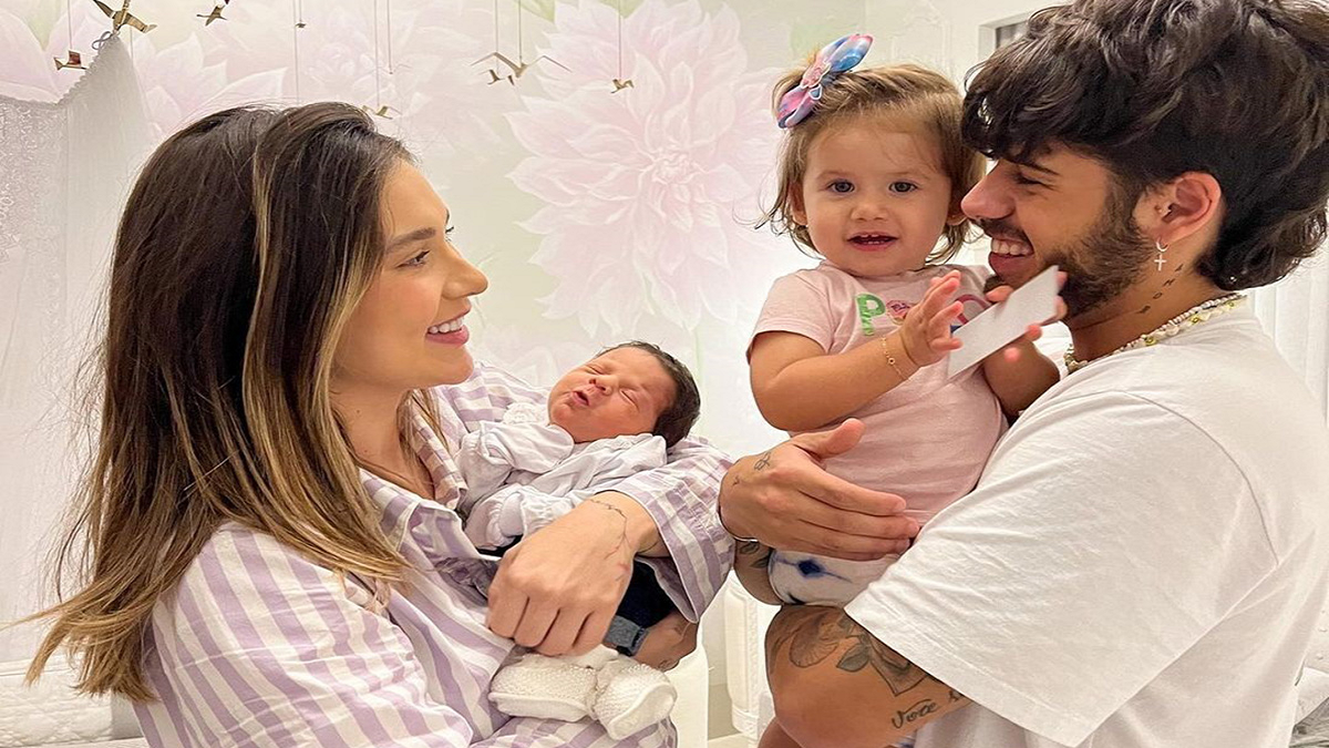Viginia com Maria Flor de 5 meses e Maria Alice de 1 e 10 meses no colo de seu pai Zé Felipe. Imagem: Web.