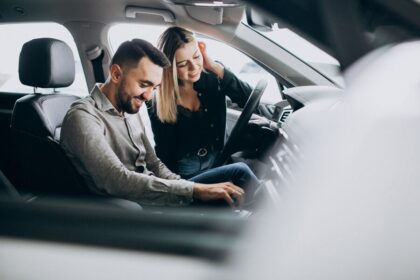 casal jovem escolhendo um carro em uma sala de show de carro 1303 20293